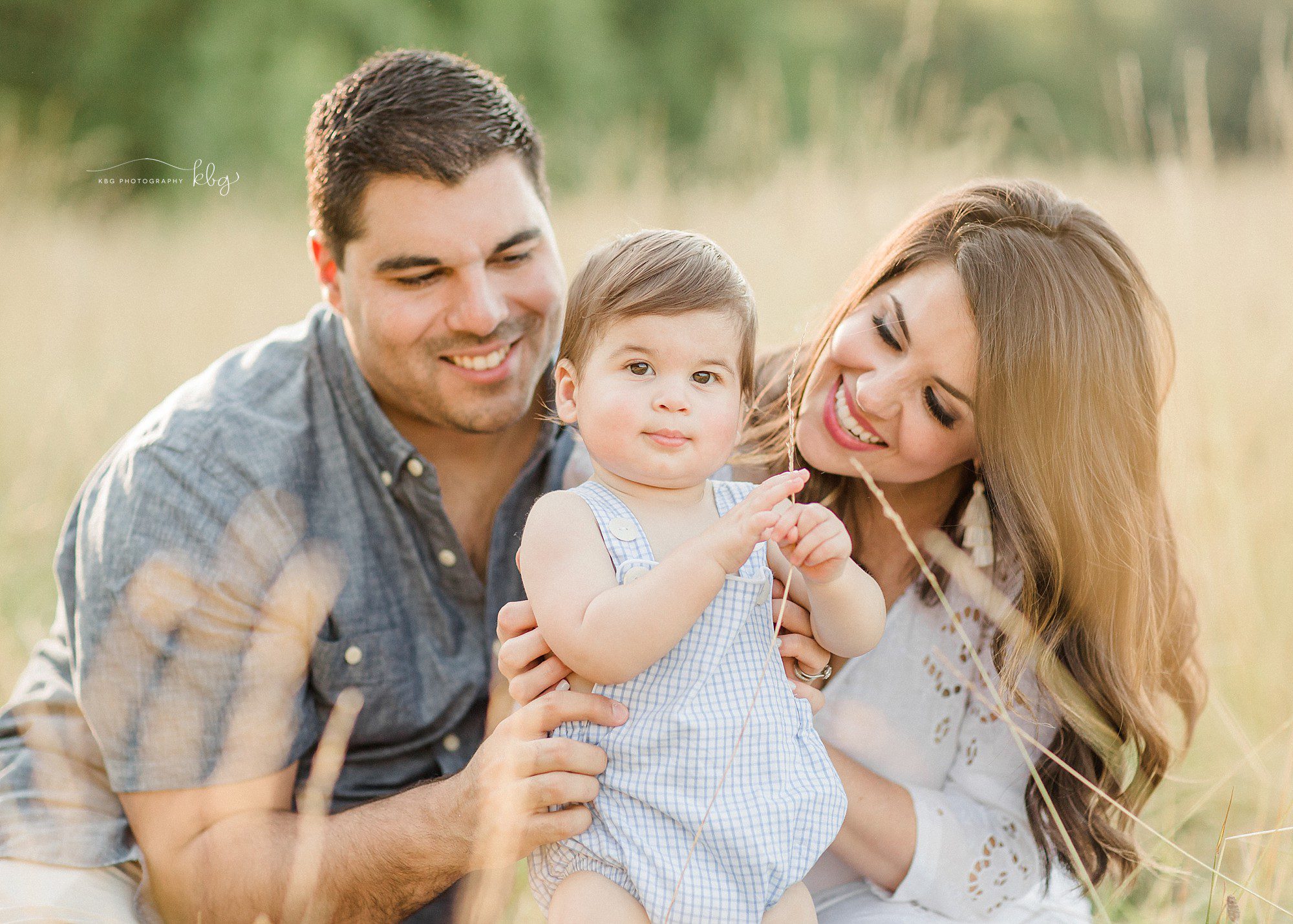 marietta family photographer - family portrait - family of three smiling together in a field