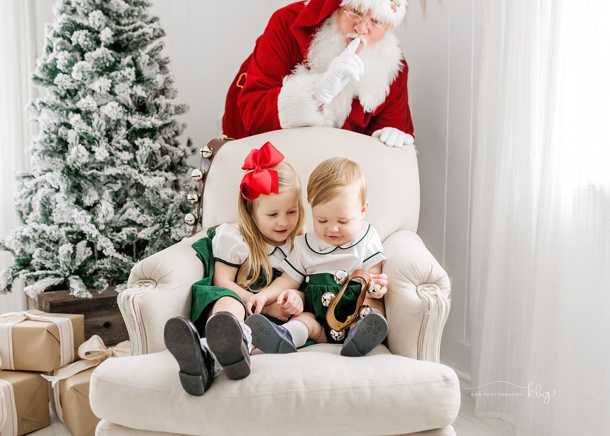 Siblings in big chair posing with santa - marietta child photographer