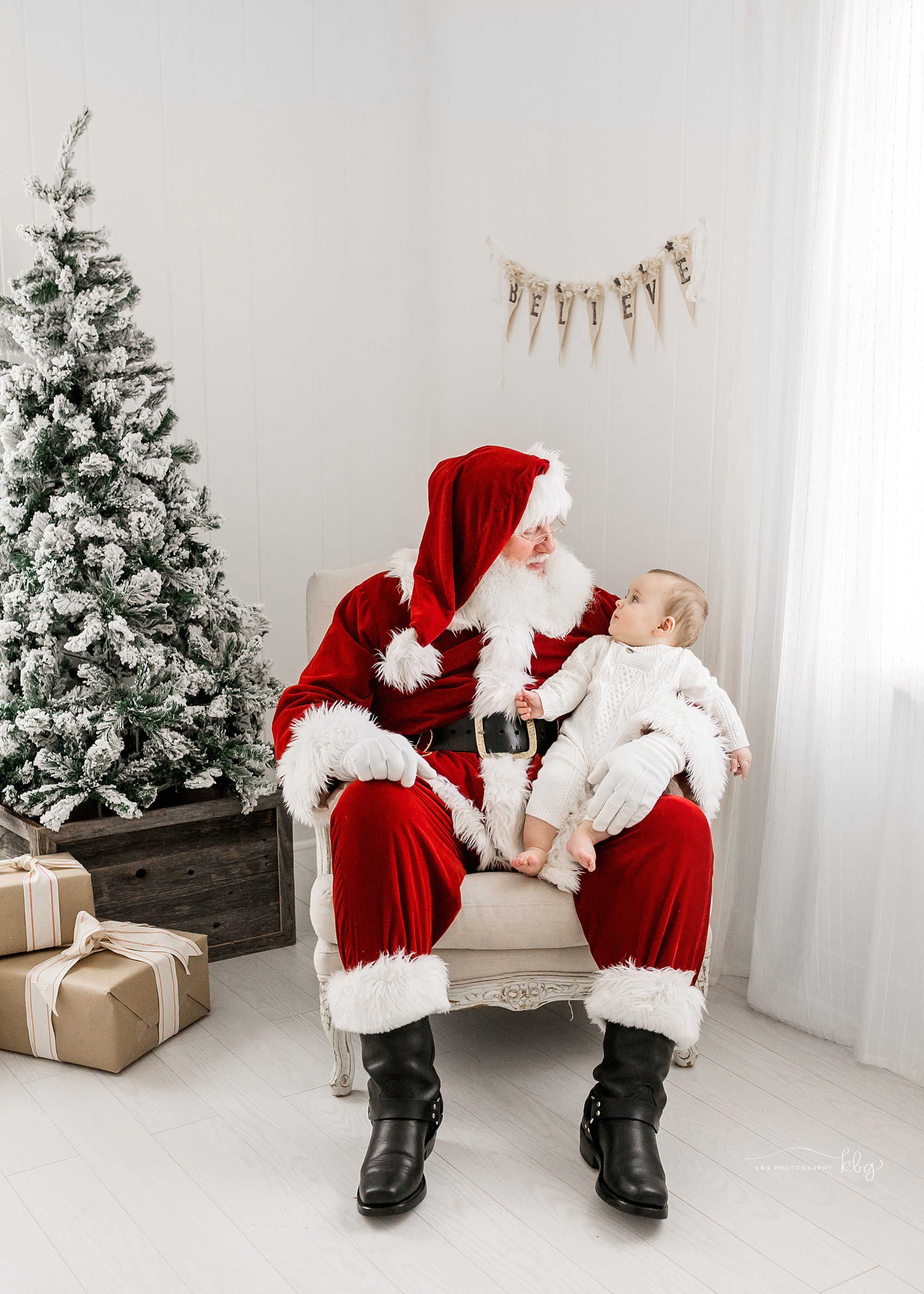 baby sitting with santa looking up at him - atlanta santa mini sessions