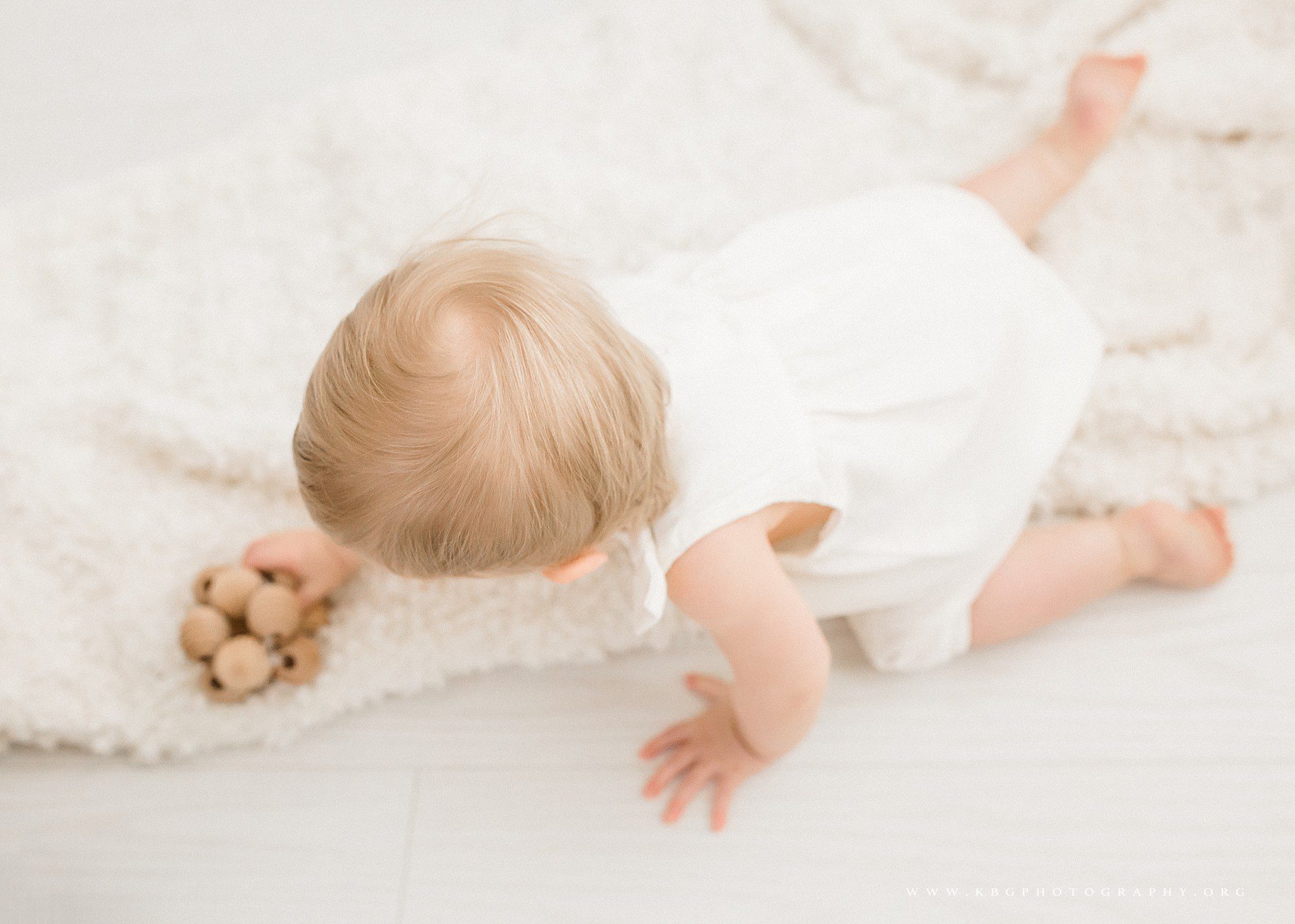 marietta family photographer - one year old baby playing with a toy on a blanket