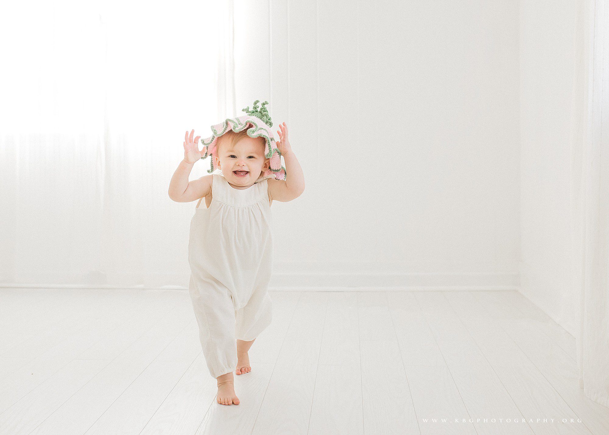 atlanta family photographer - one year old baby being silly and playing with her toy on her head