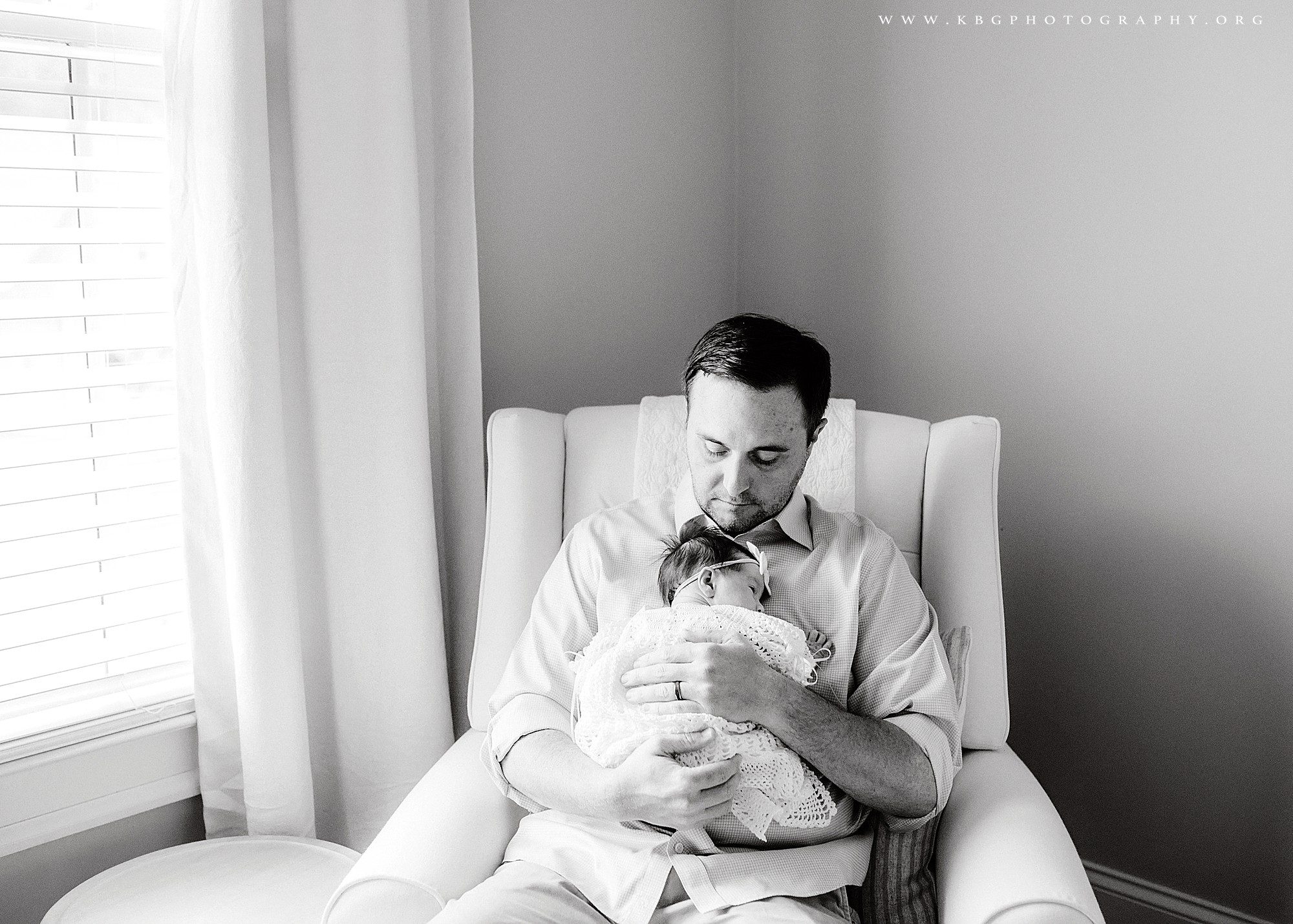 dad with newborn baby girl in nursery - marietta newborn photographer