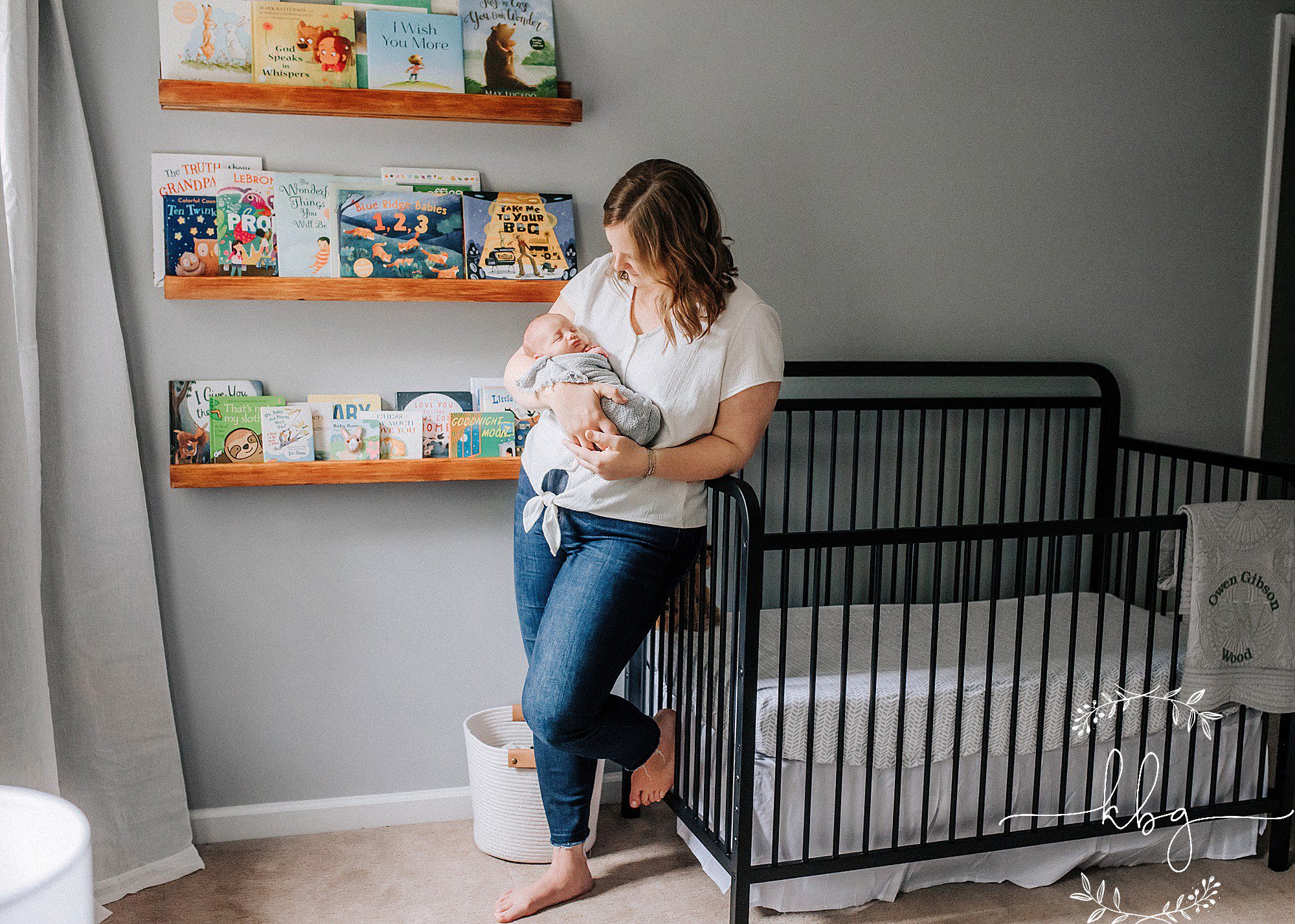 new mom holding baby in nursery - marietta baby photographer