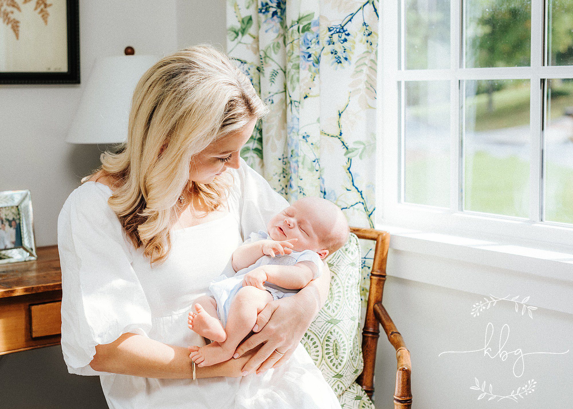 mom holding new baby by window - marietta newborn photographer