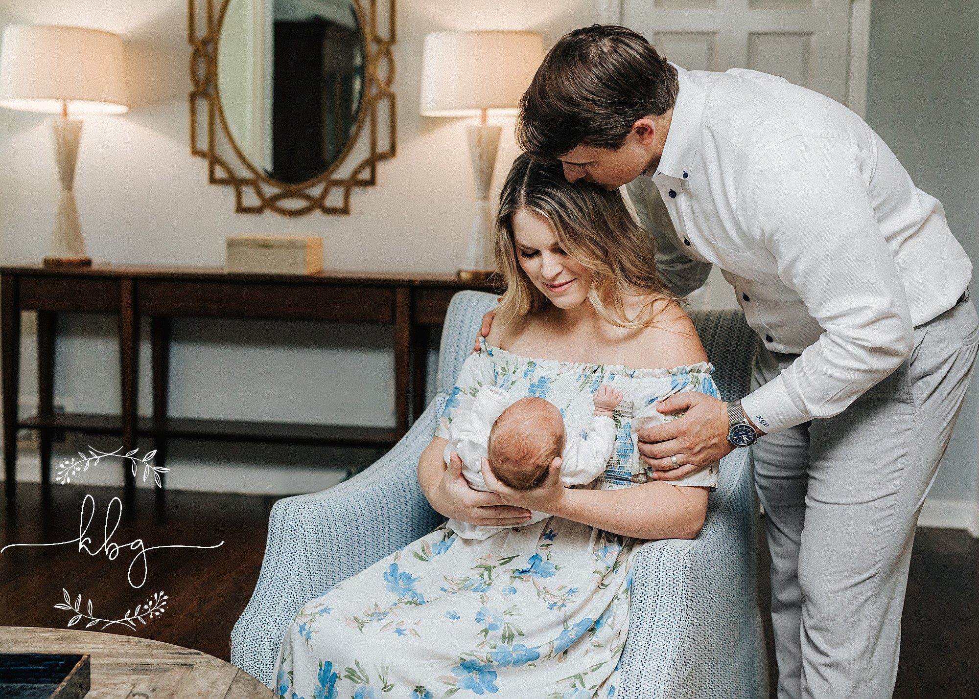 new mom holding baby boy with dad kissing her on the head - atlanta lifestyle newborn photographer