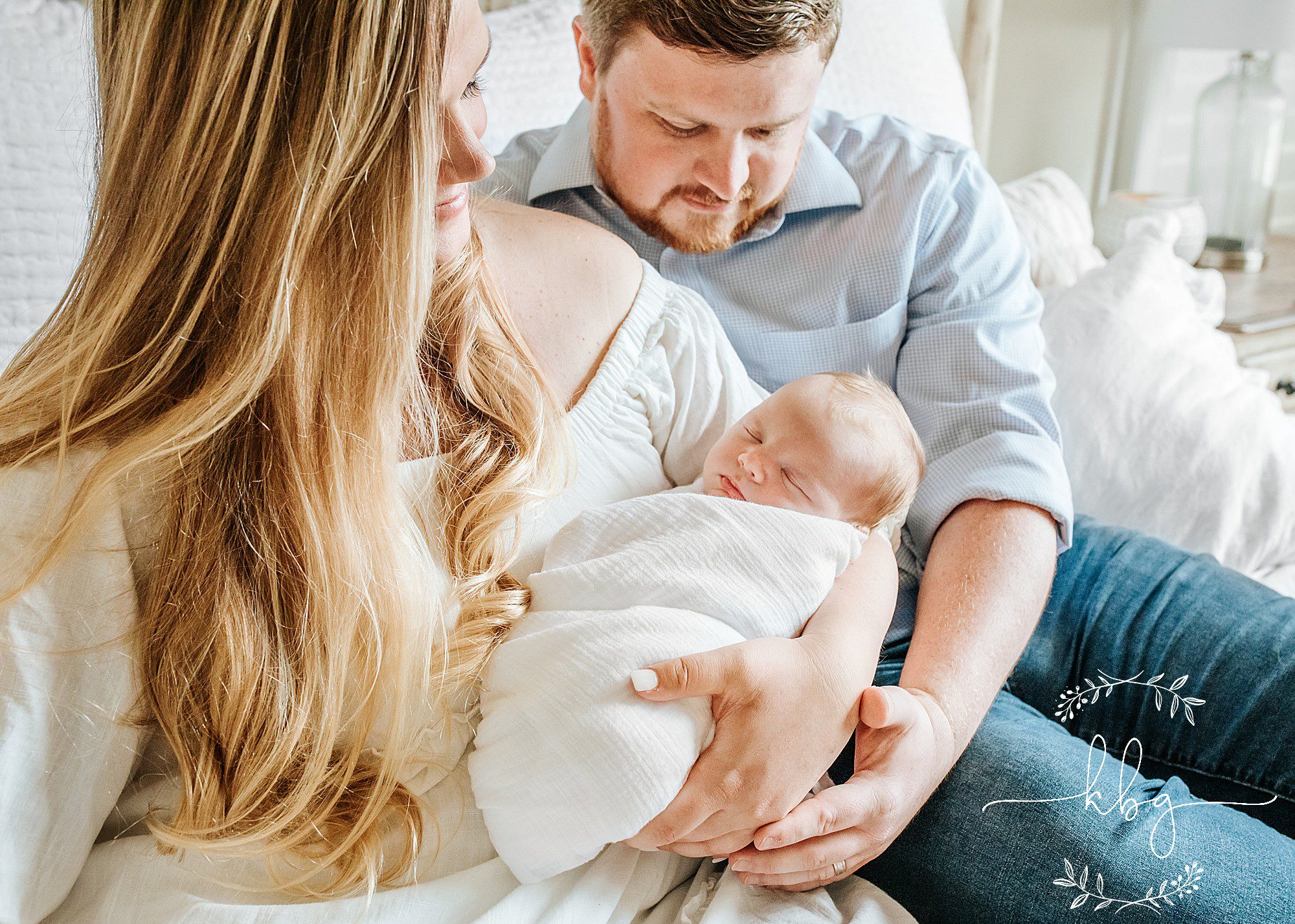 family of three on bed - east cobb newborn photographer