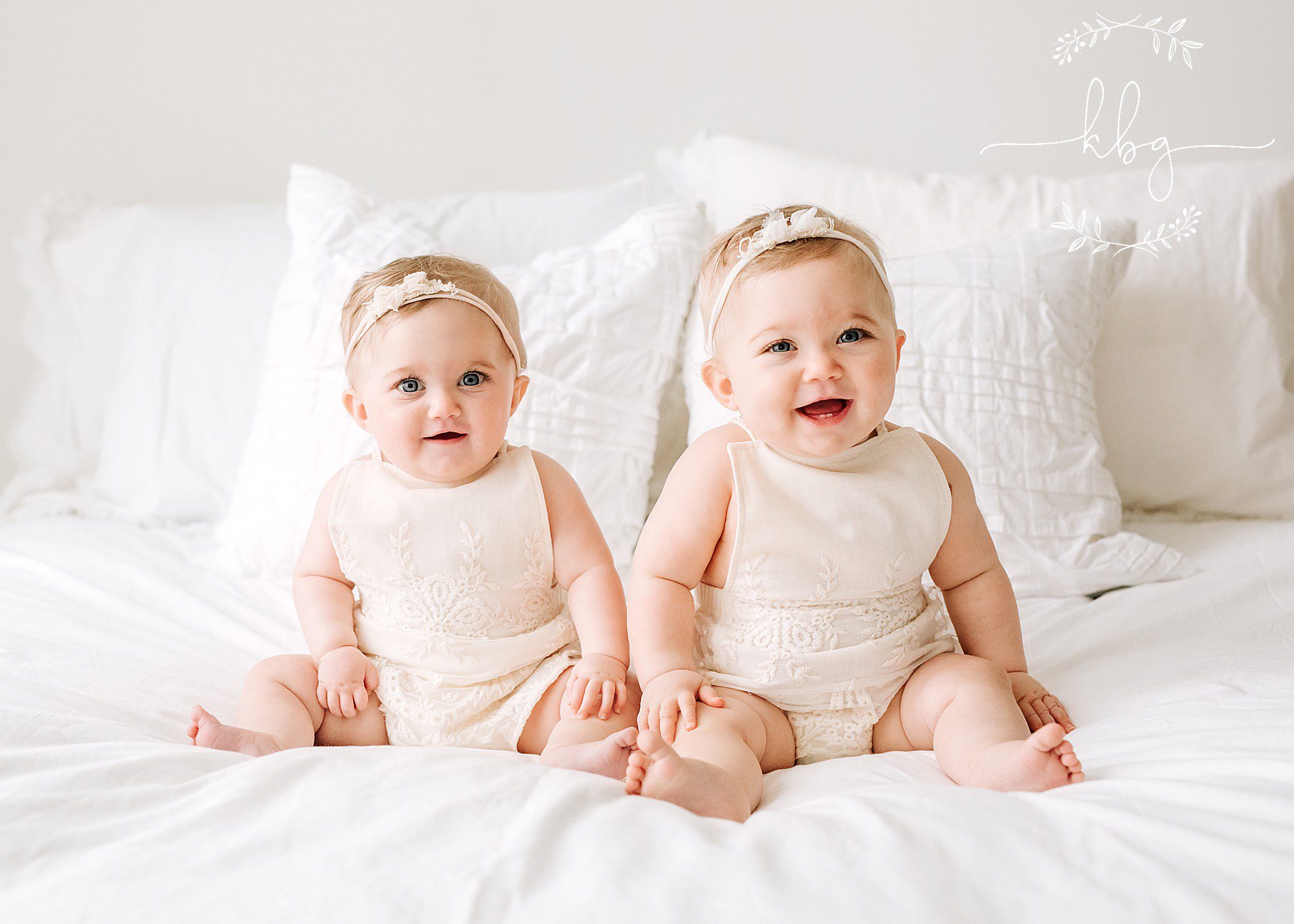 twin babies sitting on bed posing - Marietta studio photographer